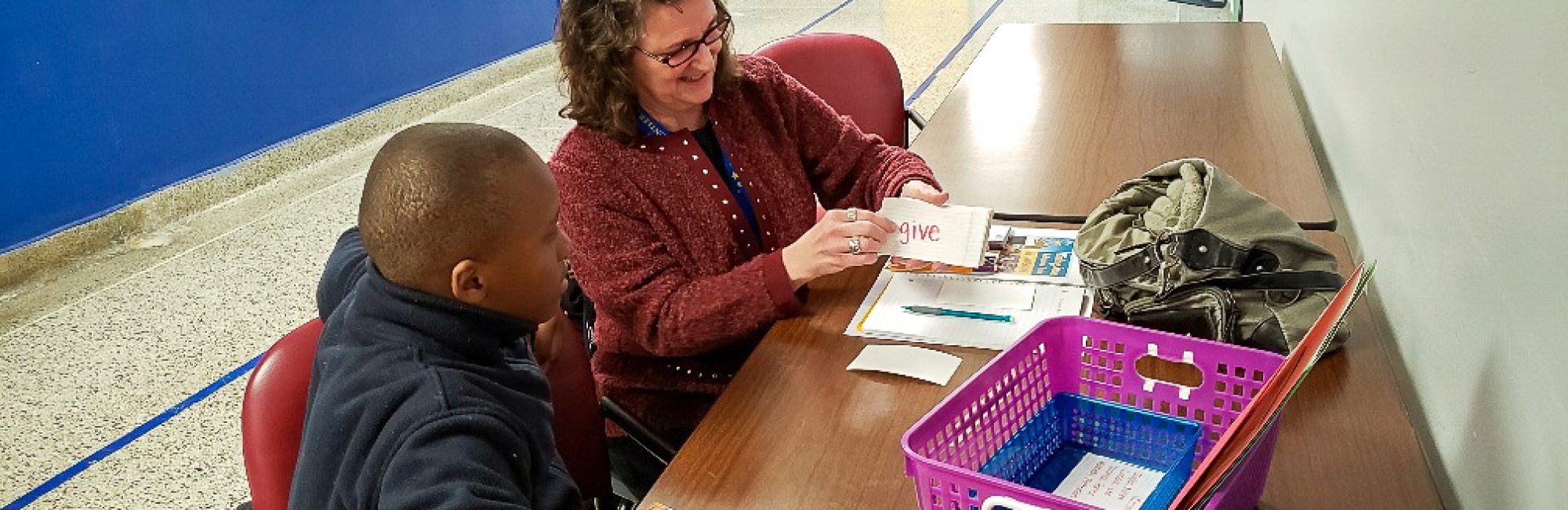 Photo of Kathy Schulfer tutoring a Messmer Saint Rose student in reading.