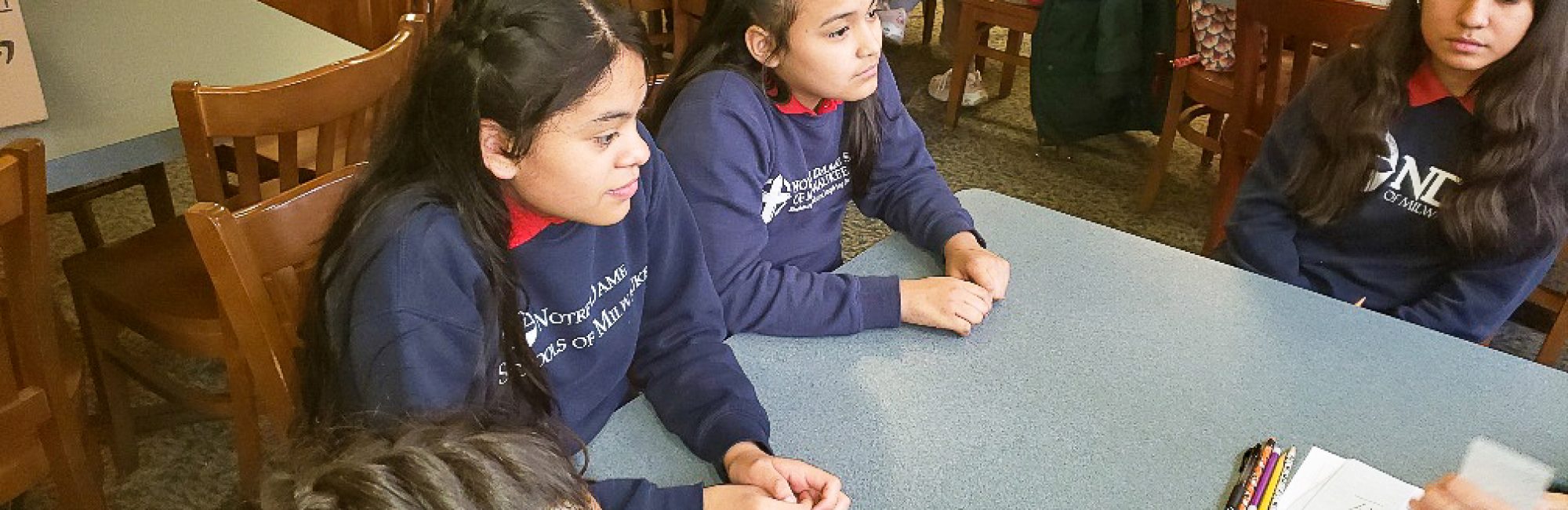 Two students from Notre Dame School of Milwaukee listen intently during a tutoring session.